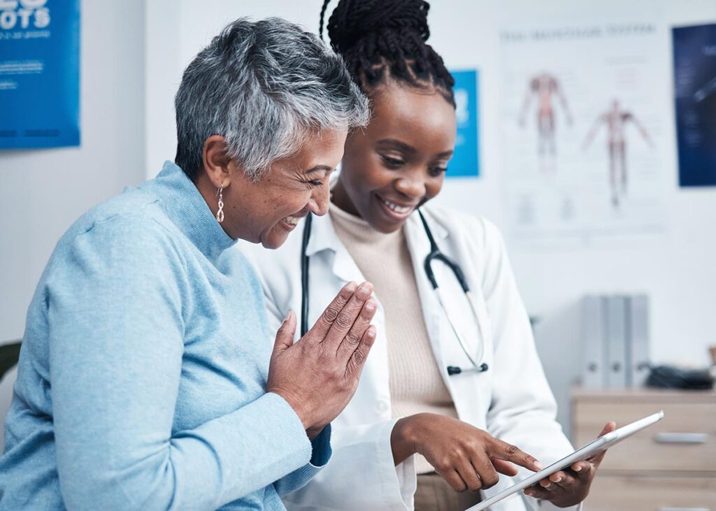 Patient and healthcare professional reviewing information on tablet 