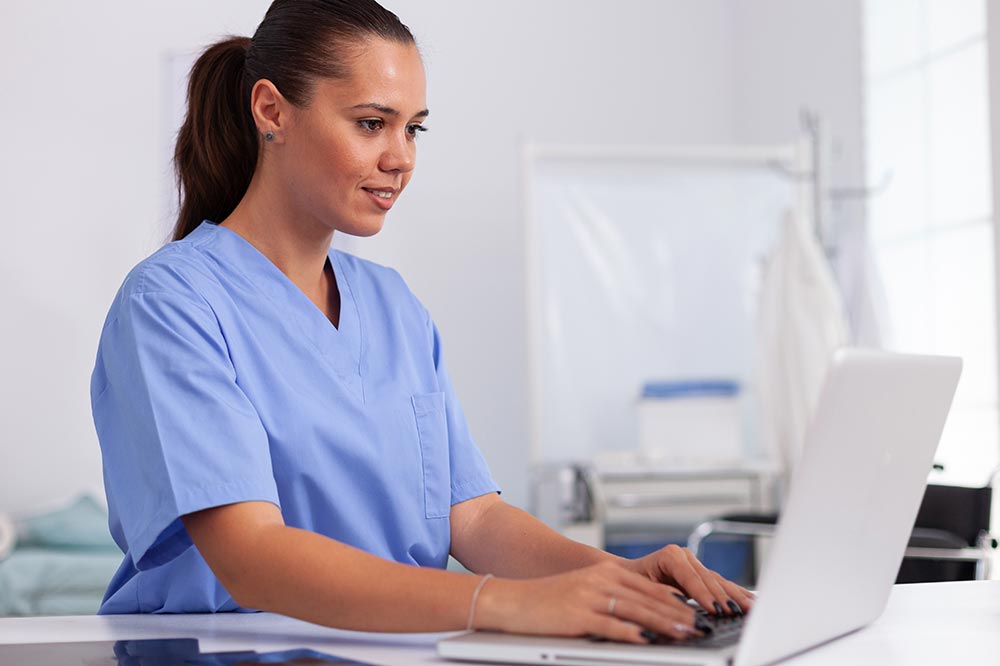 A young medical professional reviews menopause slides on a laptop.