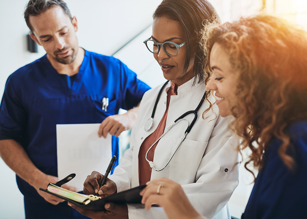 Group of three healthcare professionals reviewing information.