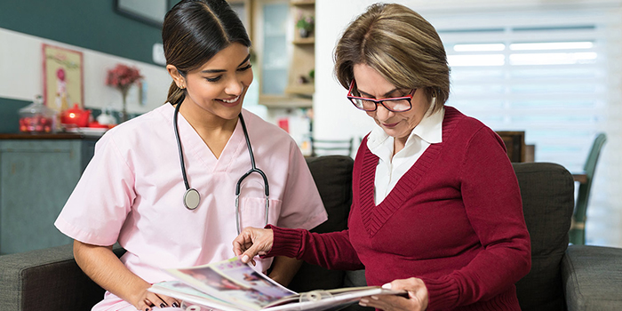 Healthcare professional on couch reviewing information with patient.