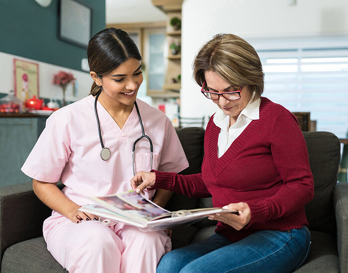 Healthcare professional on couch reviewing information with patient.