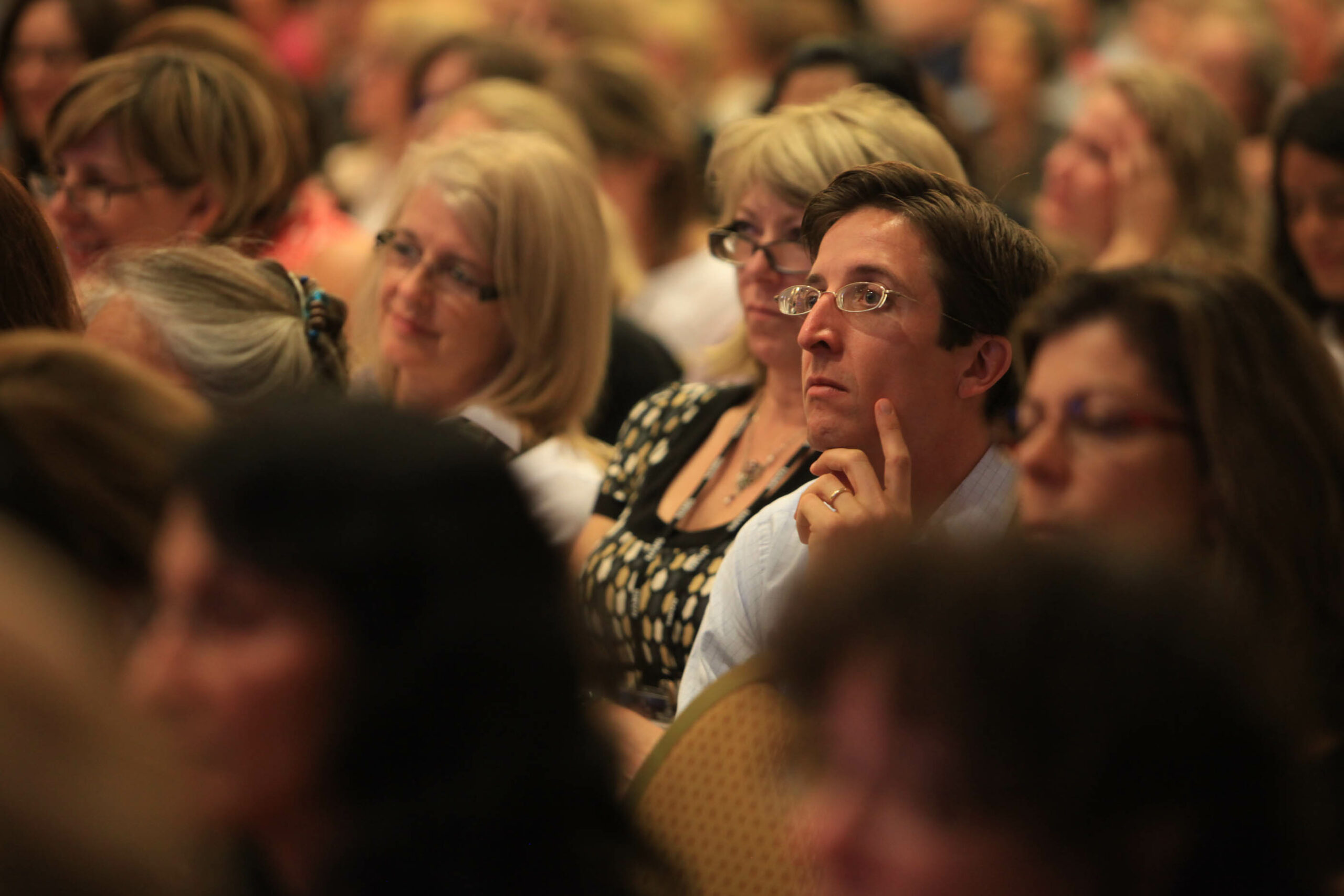 A man listens to a speaker at a conference