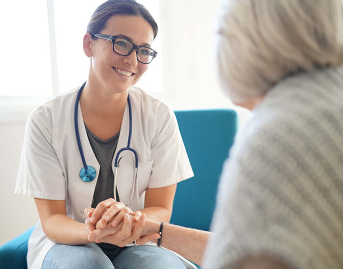 Patient holding hand with healthcare professional.